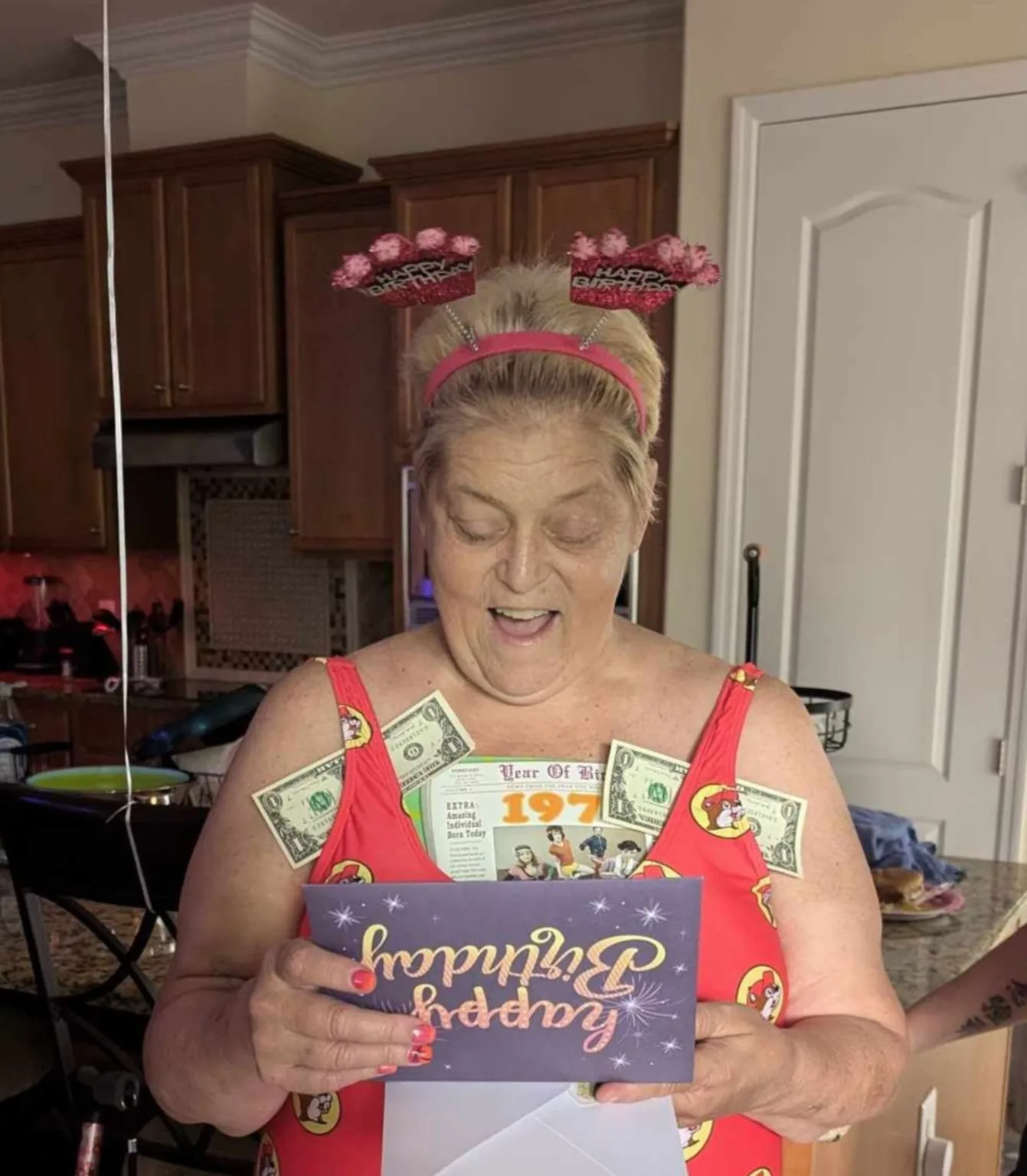 Lisa opening a birthday card and smiling at a birthday surprise