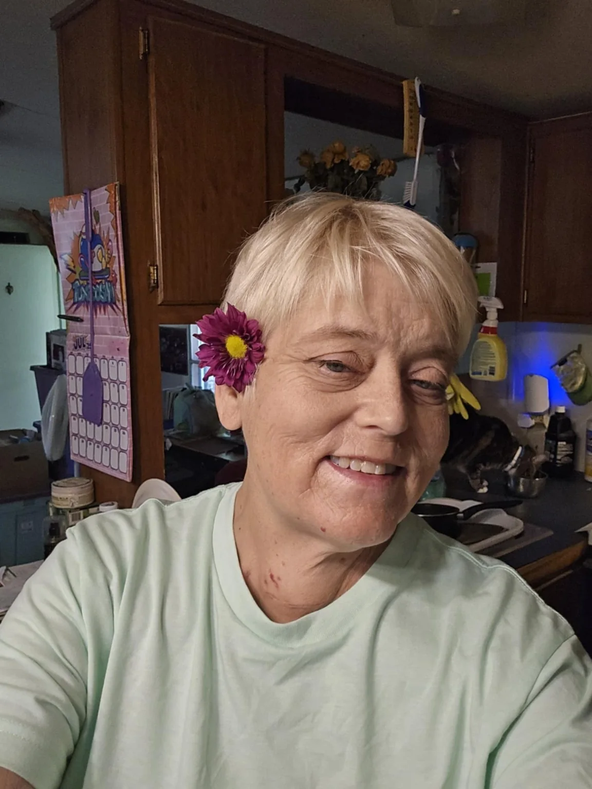 Lisa smiling with a flower tucked by her ear