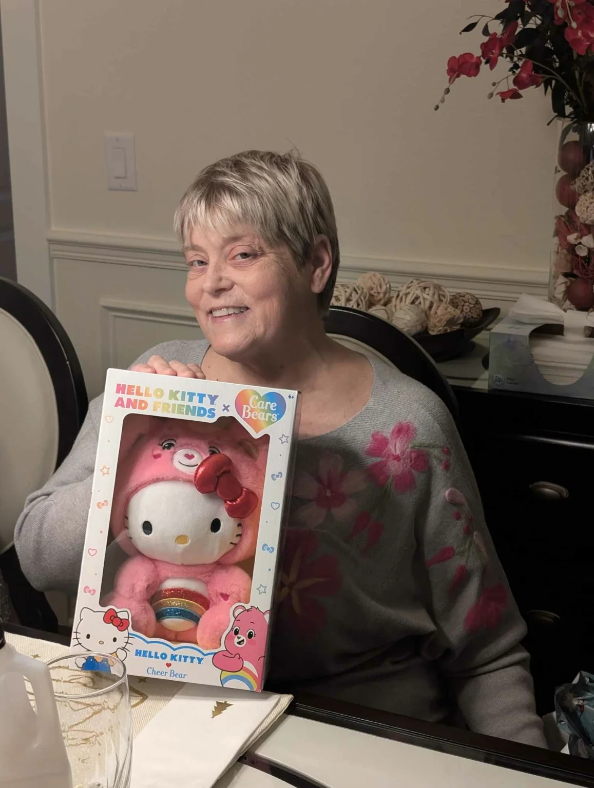 Lisa smiling while holding a Hello Kitty and Care Bears gift